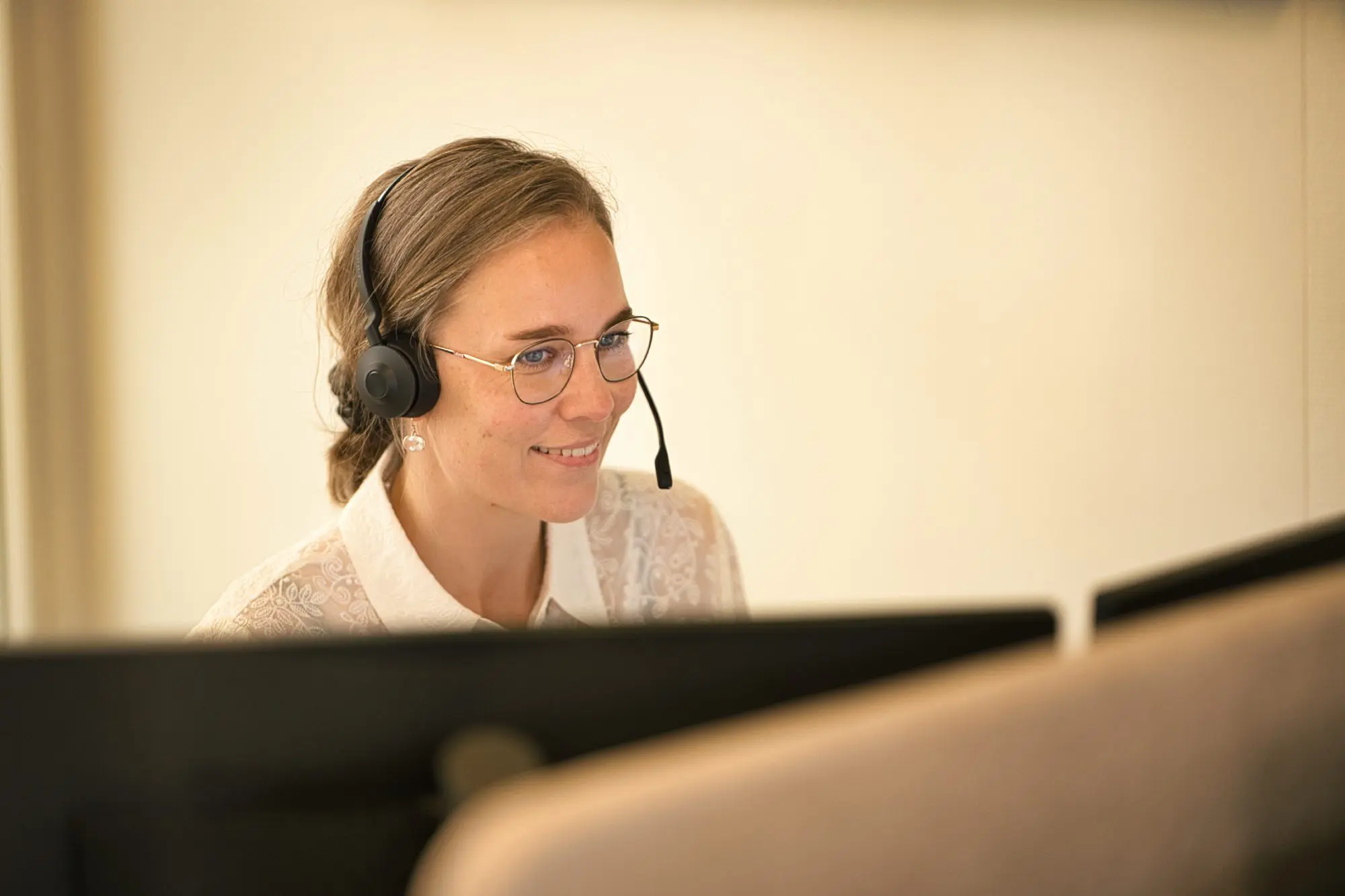 Medarbejder med headset besvarer henvendelser hos MEDIPRAX
